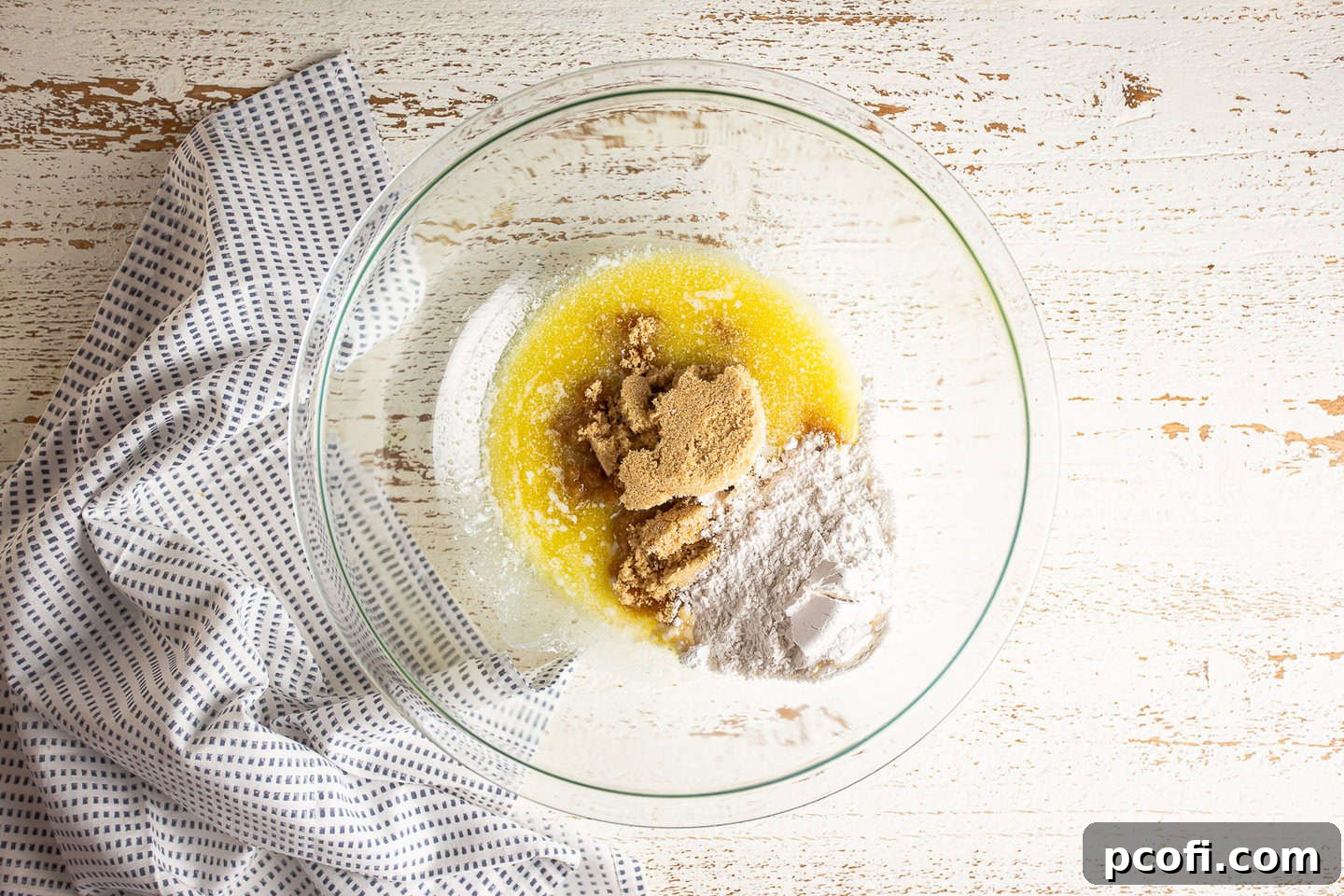 Melted butter, light brown sugar, and flour in a large glass mixing bowl.