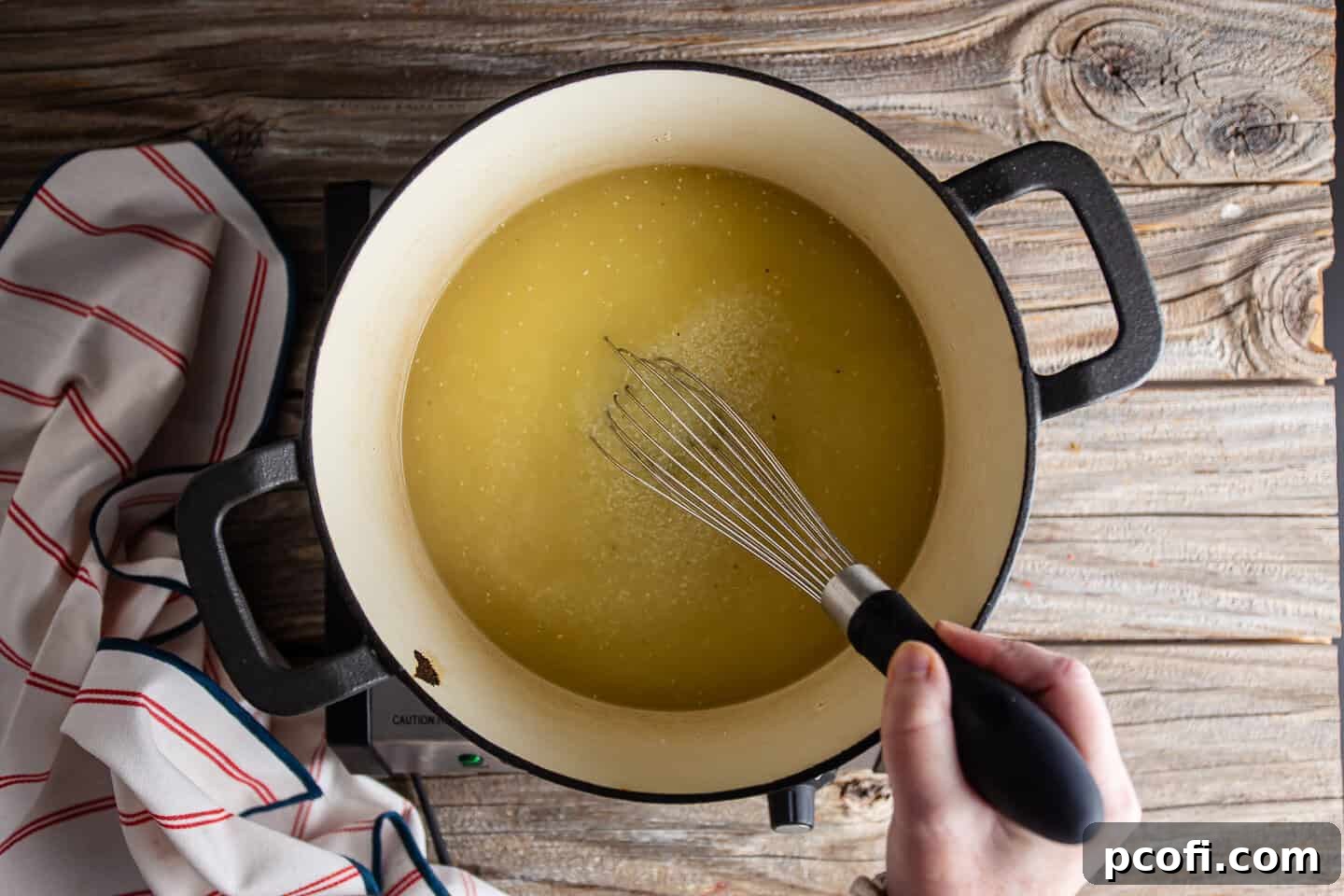 Whisking grits into boiling chicken stock.
