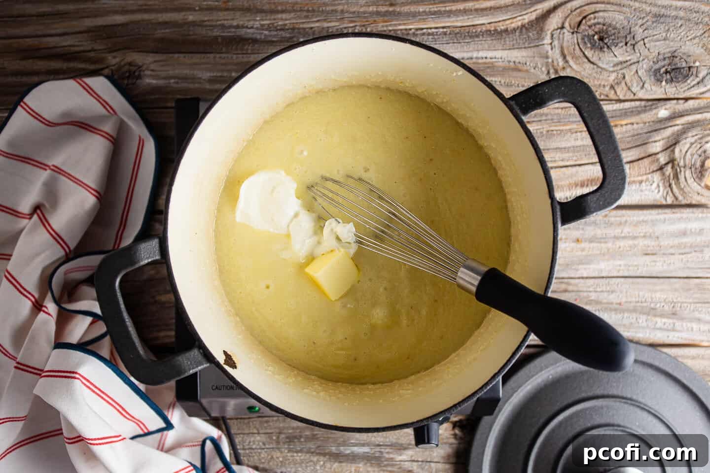 Adding sour cream and butter to cheesy grits.