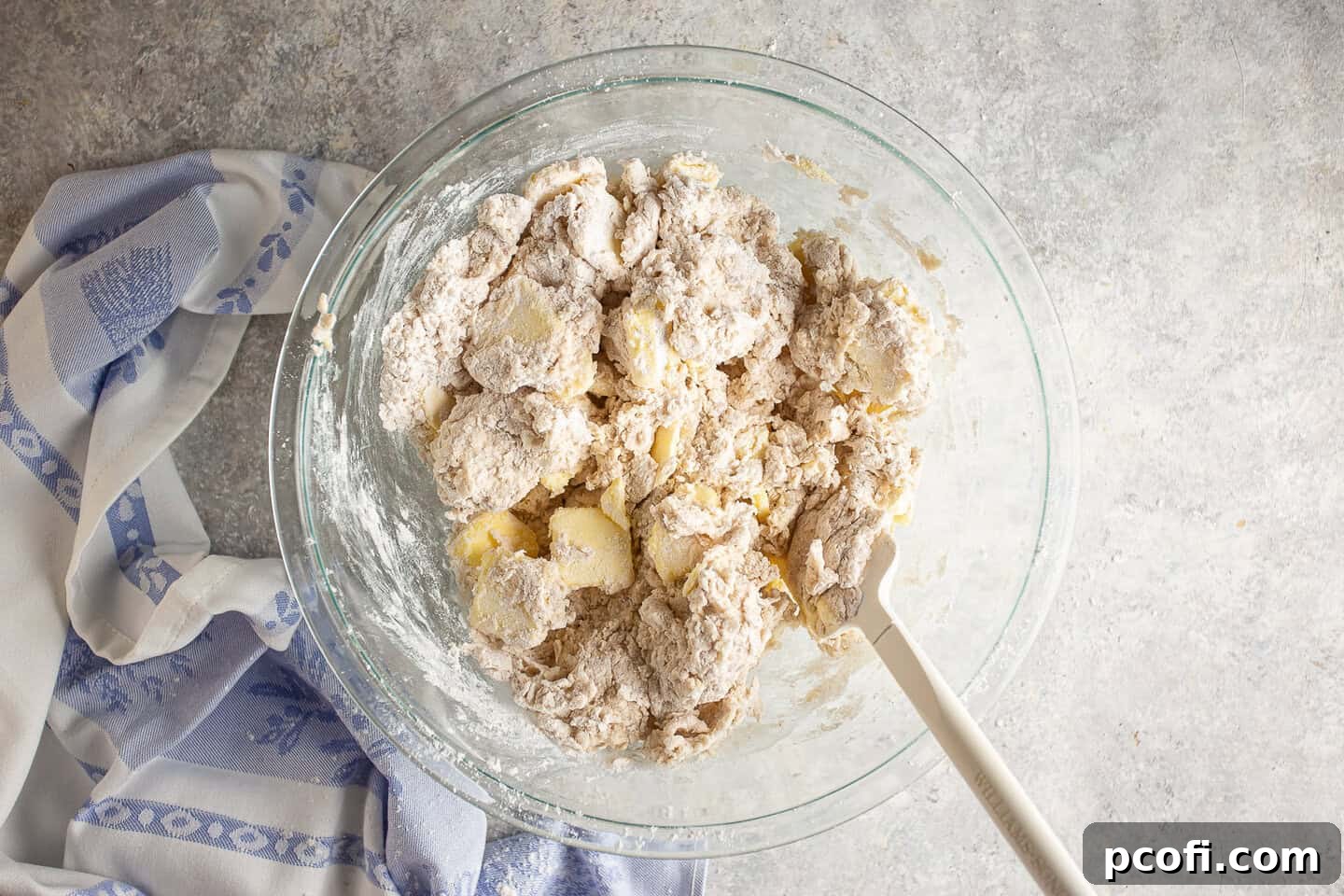 Mixing dry ingredients with cold milk to form a stiff dough.