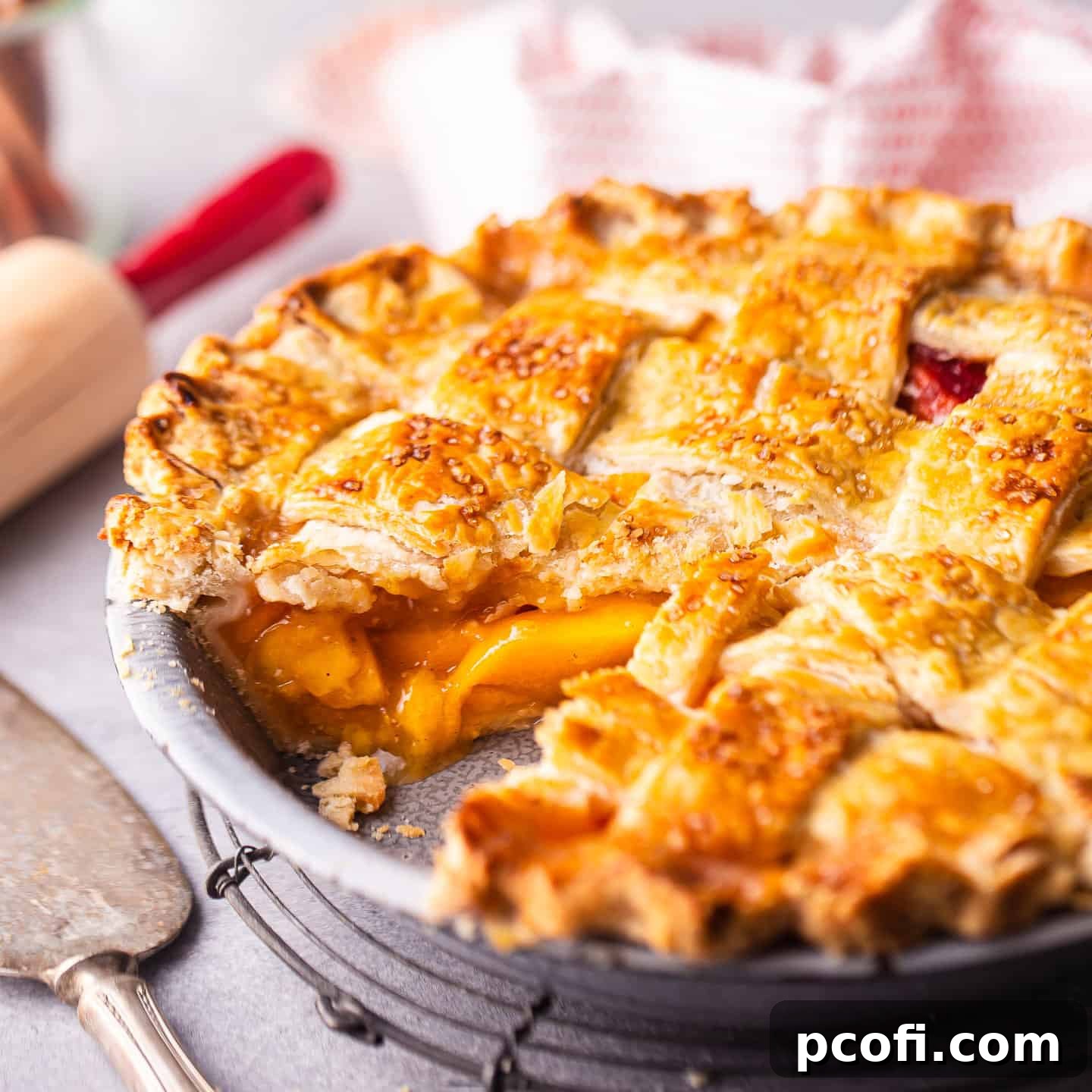 Peach pie recipe prepared and served with a slice cut out, displaying the juicy filling.
