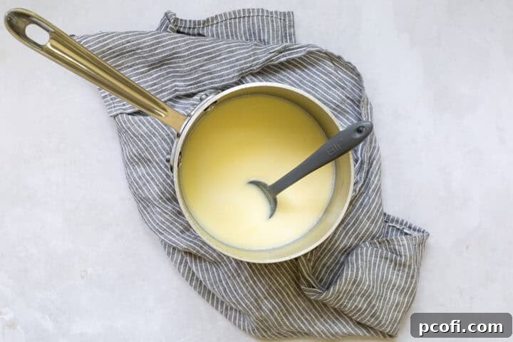 Milk and butter melting in a small saucepan on the stovetop.