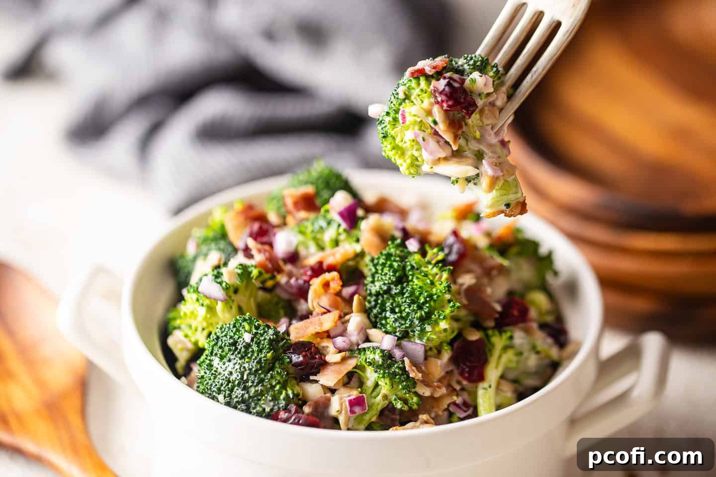 A forkful of savory broccoli salad with crispy bacon, showcasing the perfect blend of ingredients and textures, ready to be enjoyed.