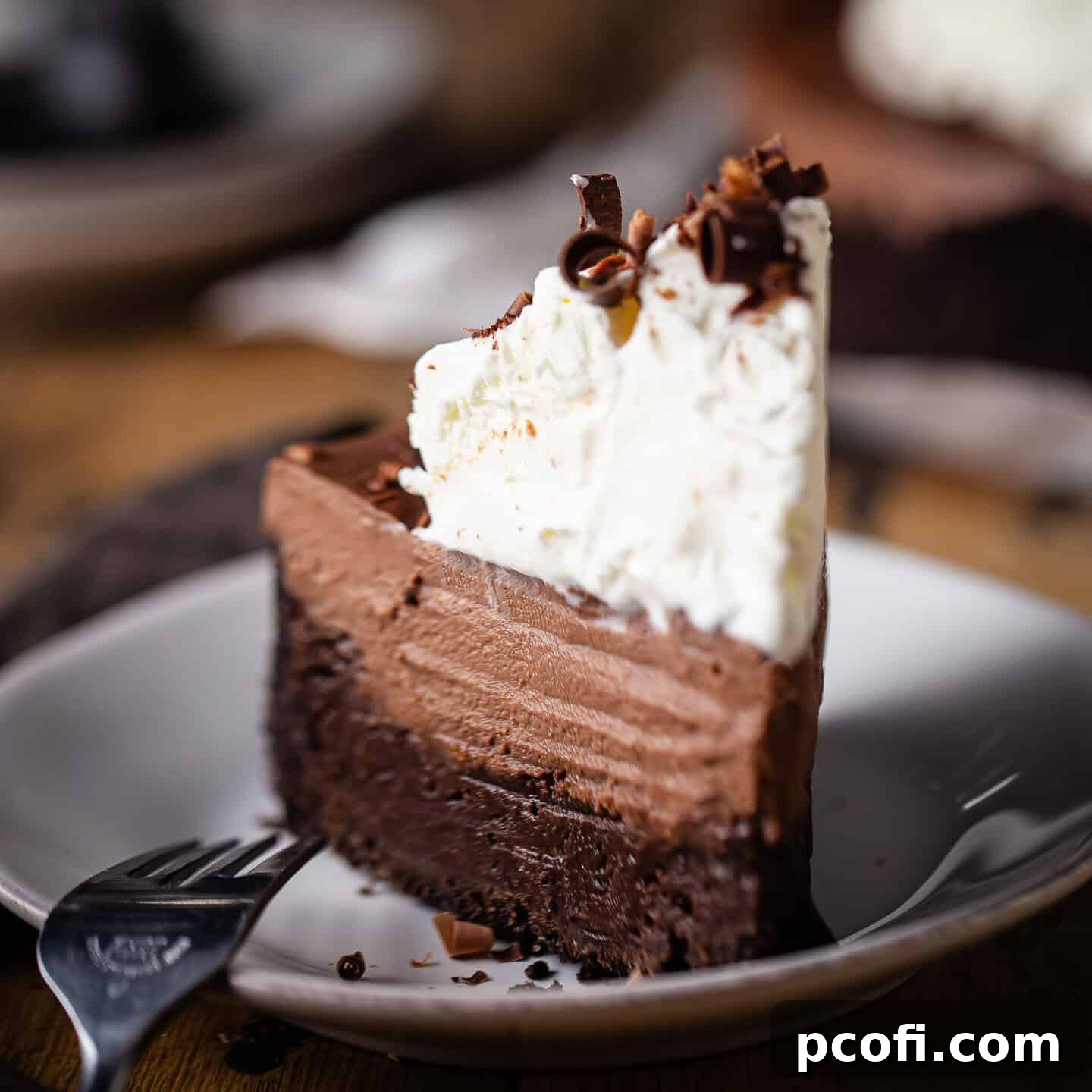 A tall slice of Mississippi mud pie on a white ceramic plate.