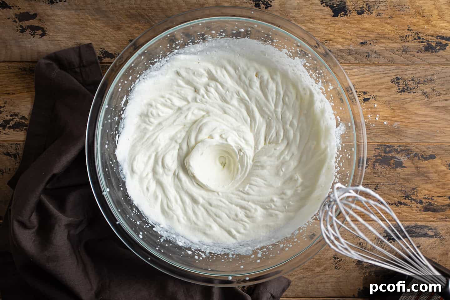 Whisking cream to soft peaks with an electric mixer.