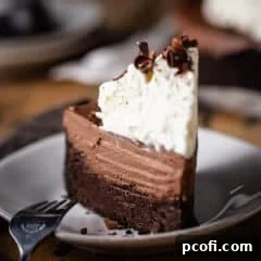A tall slice of Mississippi mud pie on a white ceramic plate.