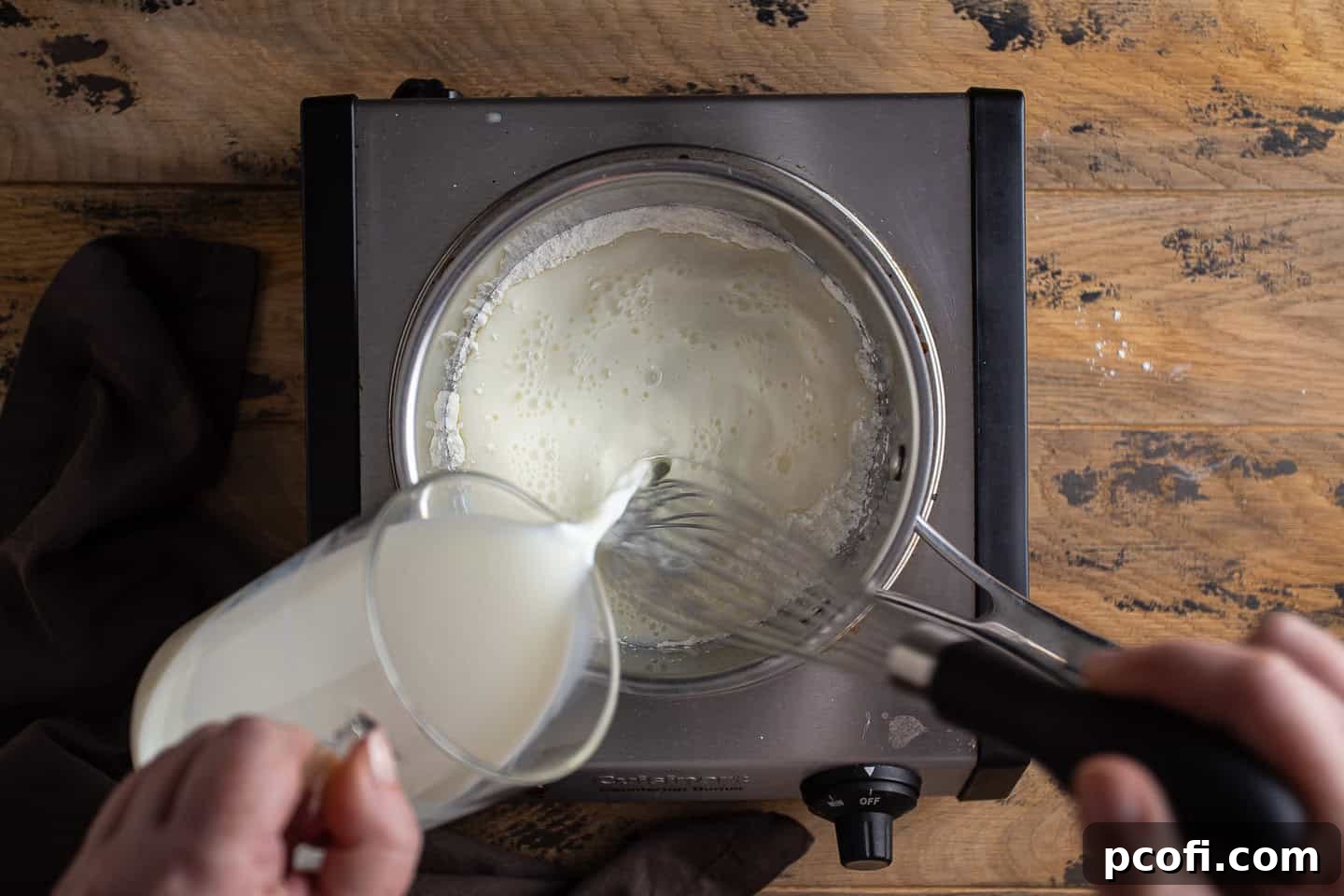 Whisking milk into sugar and cornstarch.