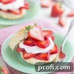 Classic Simply Perfect Strawberry Shortcake, layered with fresh, macerated strawberries, light whipped cream, and tender buttermilk biscuits.