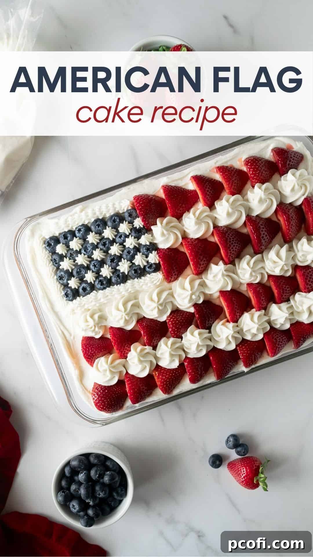 A vibrant American flag cake, featuring white frosting, red strawberries, and blue blueberries, presented in a baking pan, ready for serving at a patriotic celebration.