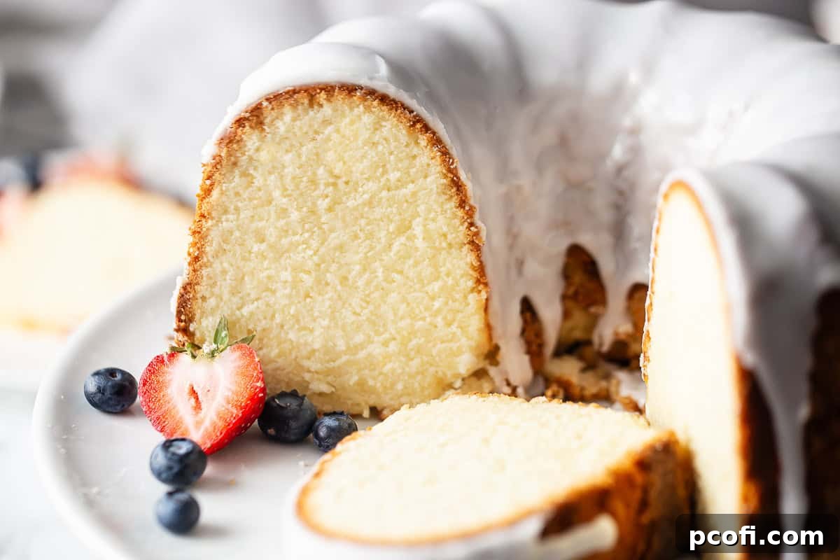 Pound cake recipe using cream cheese, baked in a bundt pan and garnished with fresh berries.