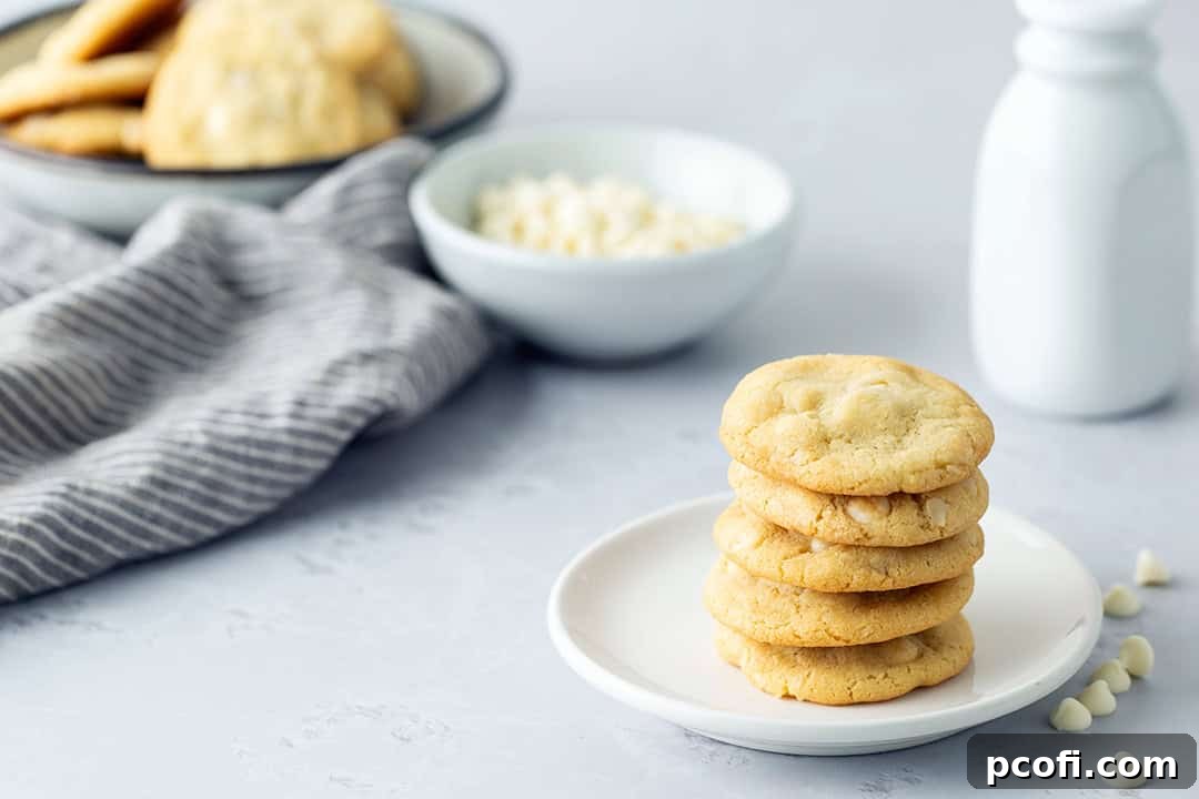 A stack of White Chocolate Macadamia Nut Cookies on a plate.