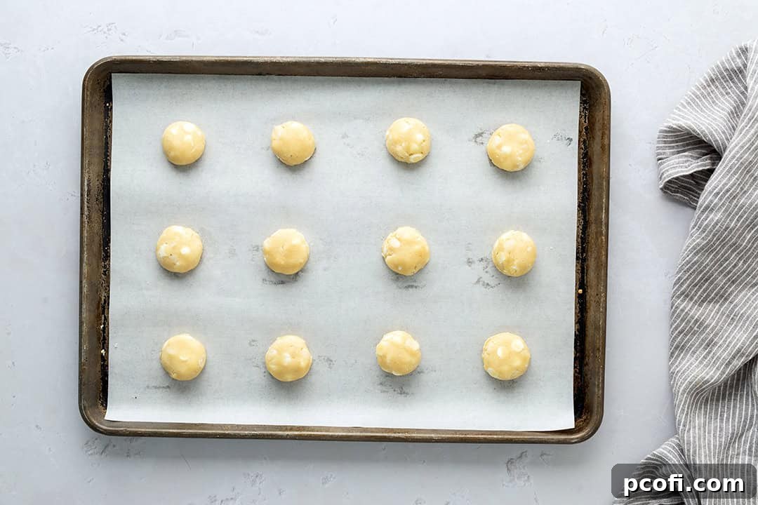 Cookie dough scooped onto a baking sheet lined with parchment.