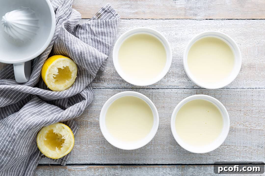 Lemon posset mixture freshly poured into four individual ramekins, prepared for chilling.