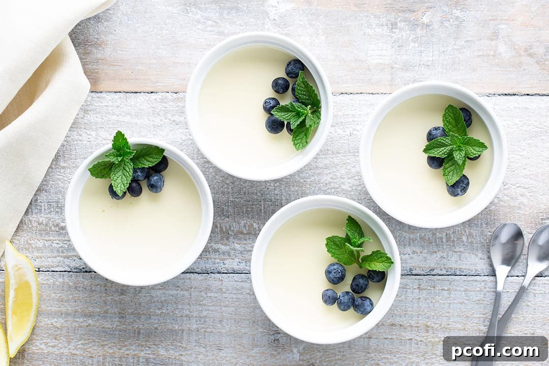Lemon posset garnished with vibrant mint leaves and fresh blueberries, ready for serving.