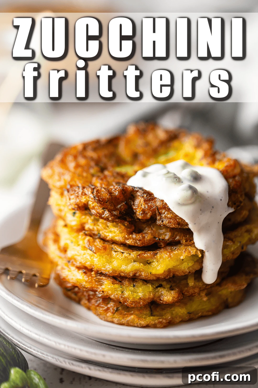 A stack of golden brown zucchini fritters on a ceramic plate, with a decorative banner overlay that proudly proclaims "Zucchini Fritters."