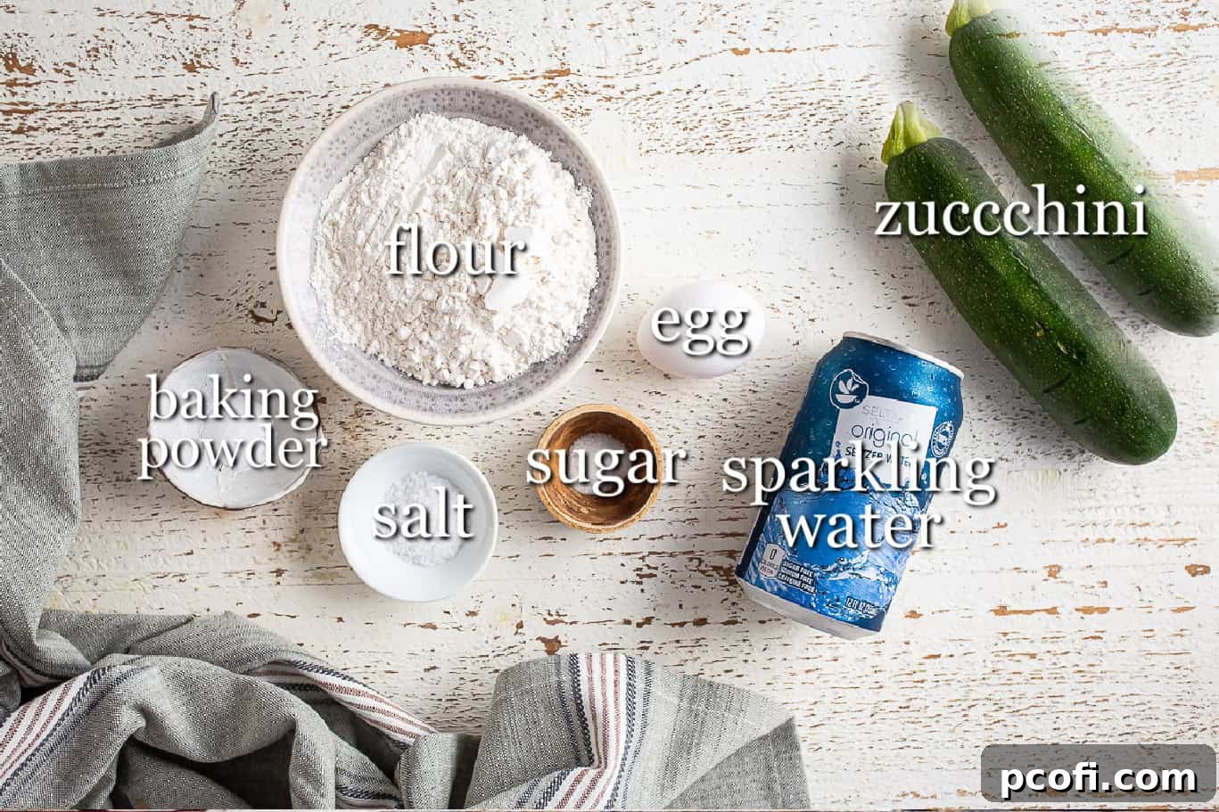 All the essential ingredients neatly laid out on a wooden surface, ready for making delicious zucchini fritters, with clear text labels.