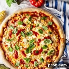 Overhead image of corn pizza with basil, tomato sauce, and Boursin cheese.
