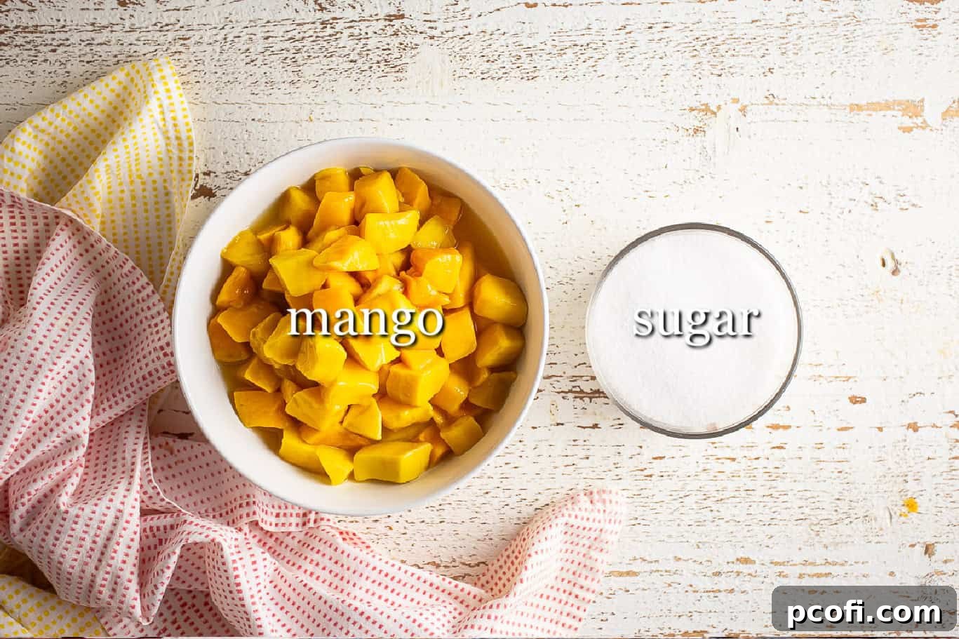 Fresh mangoes and granulated sugar laid out, the two simple ingredients needed for this easy mango sorbet recipe.