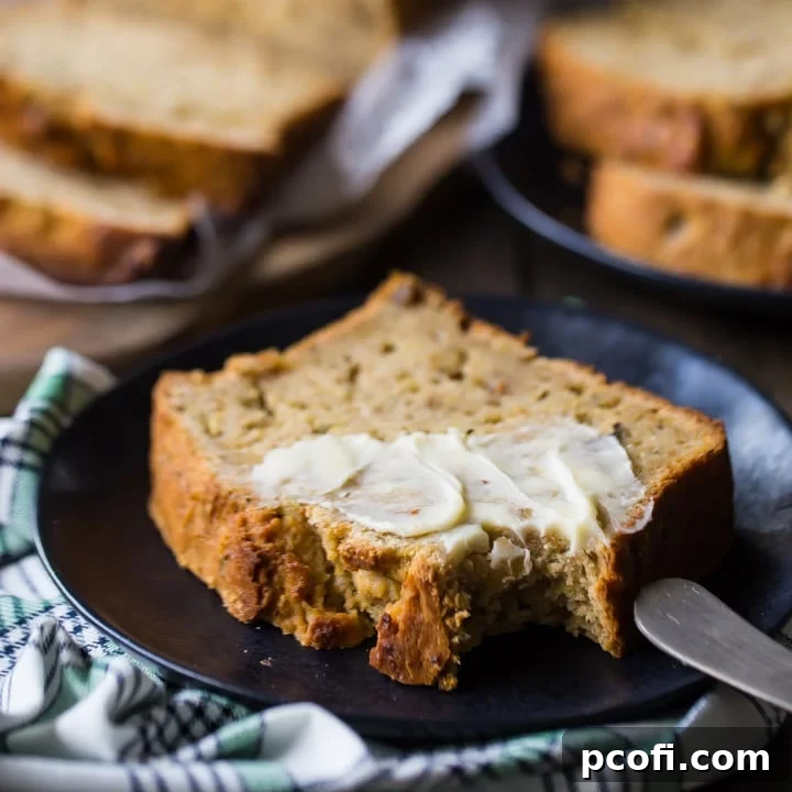 A perfect loaf of classic zucchini bread, golden brown and moist, ready to be sliced.