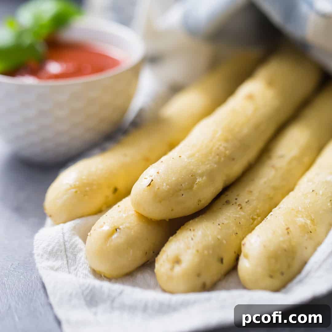 A bundle of soft Italian breadsticks, neatly wrapped in a napkin, ready to be enjoyed with a meal.