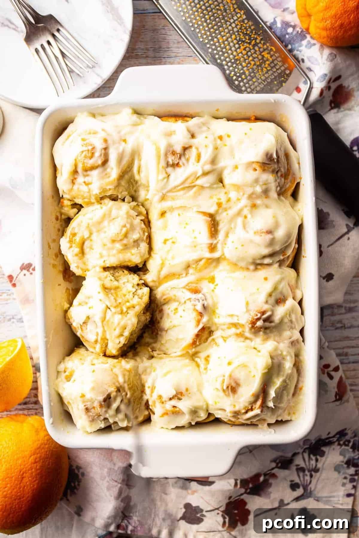 Beautifully arranged orange sweet rolls in a white rectangular baking dish, ready to be enjoyed.