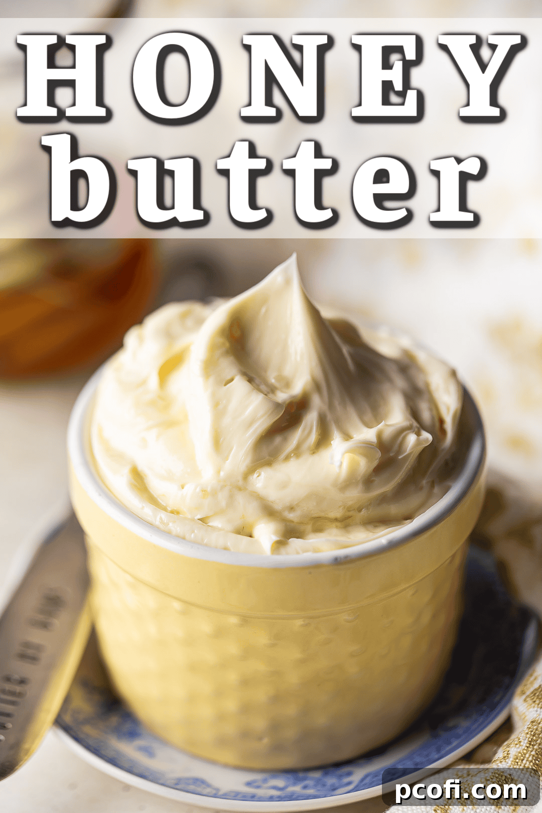 Homemade honey butter in a yellow pot with a vintage silver spreader, ready to be served.