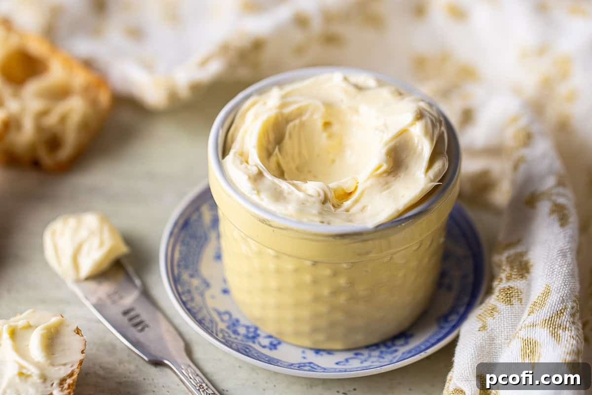 A pot of homemade honey butter surrounded by crusty bread slices, ready for a meal.