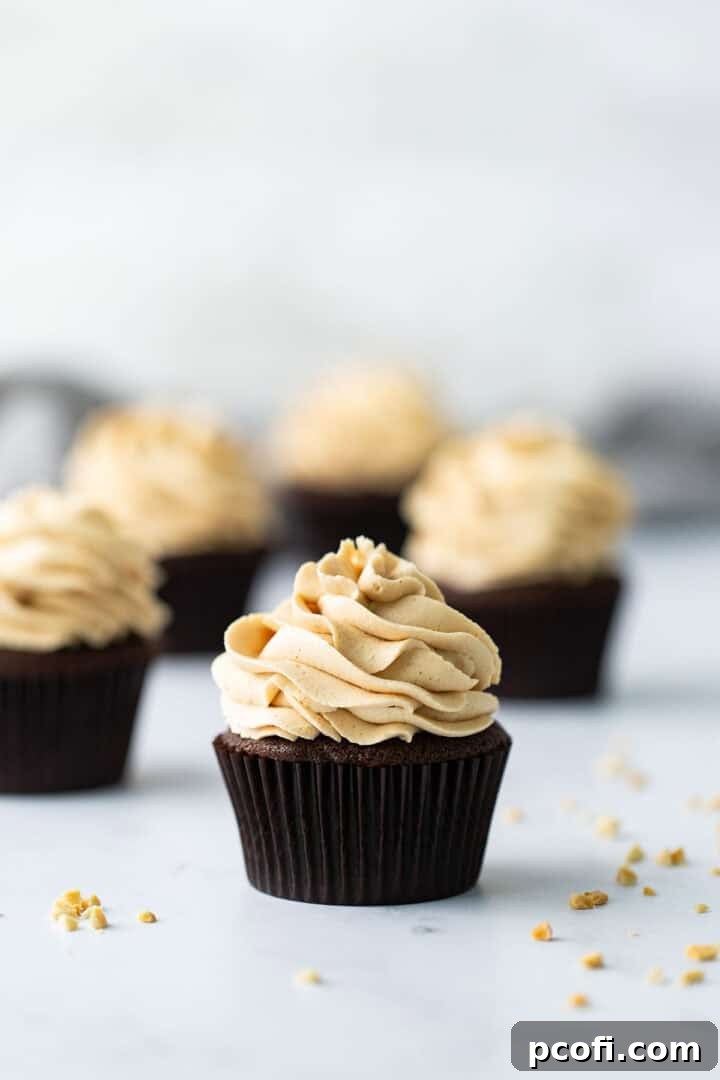 Close up shot of a frosted chocolate peanut butter cupcake, showcasing its texture and deliciousness