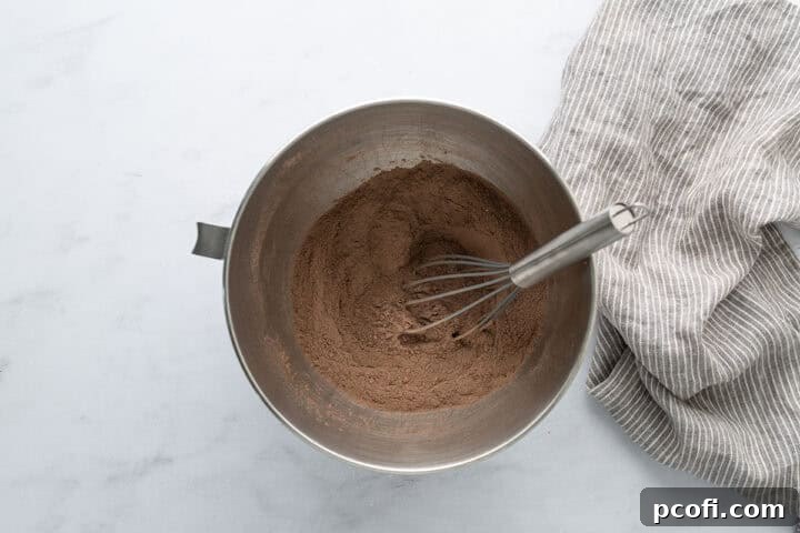Dry ingredients for chocolate cupcakes in a bowl with a whisk, ready for mixing