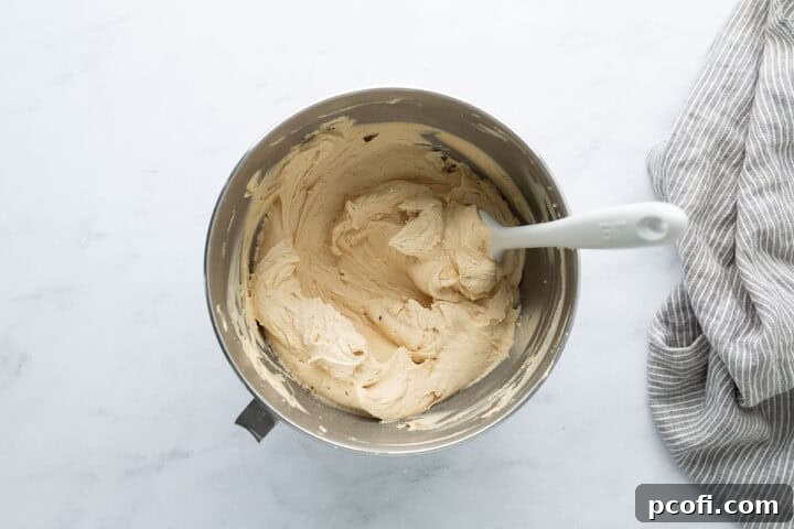 Creamy peanut butter frosting in a bowl with a spatula, perfectly smooth and ready to use