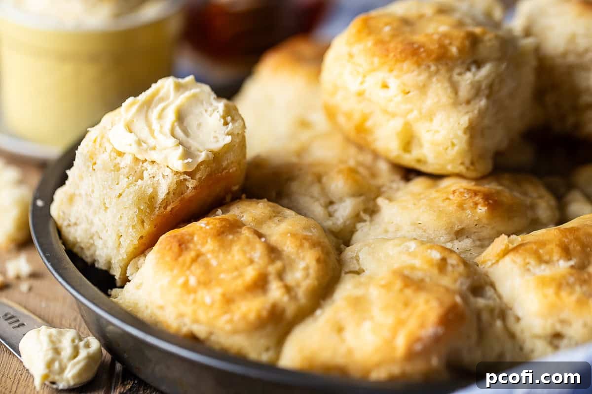 Close-up image of angel biscuits spread with honey butter.