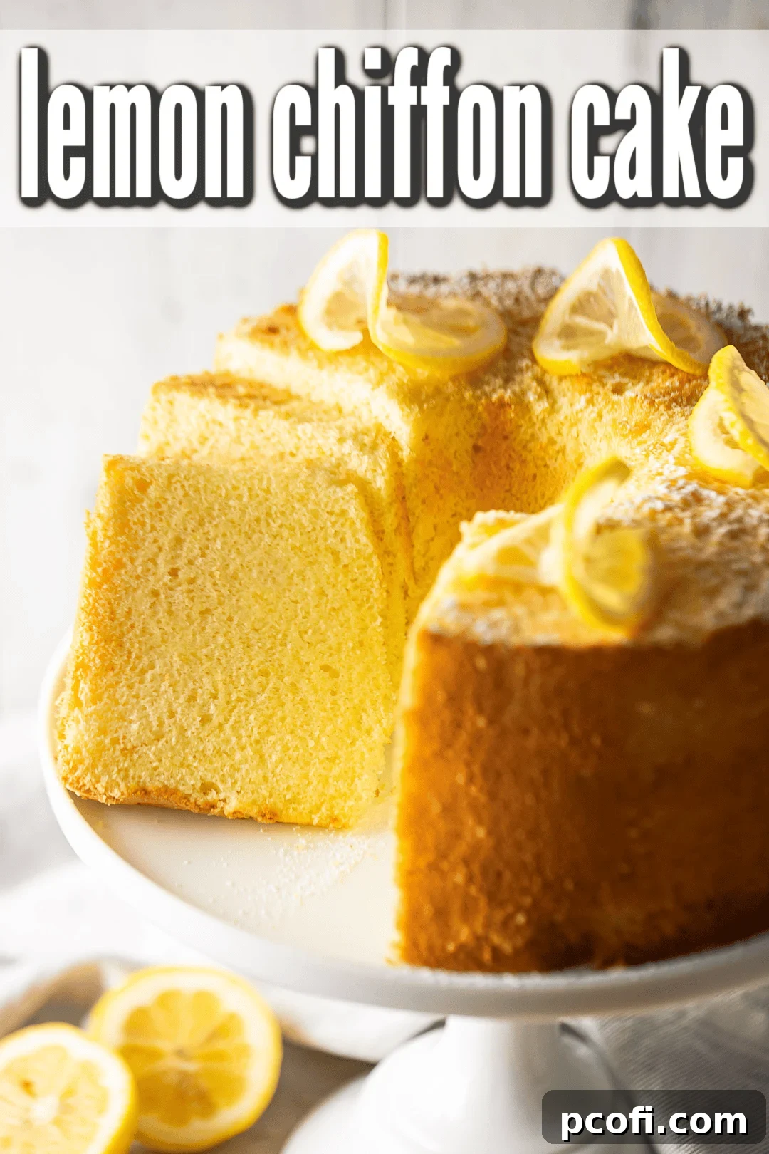 A slice of lemon chiffon cake removed, revealing its fluffy interior, adorned with elegant lemon twists on top.