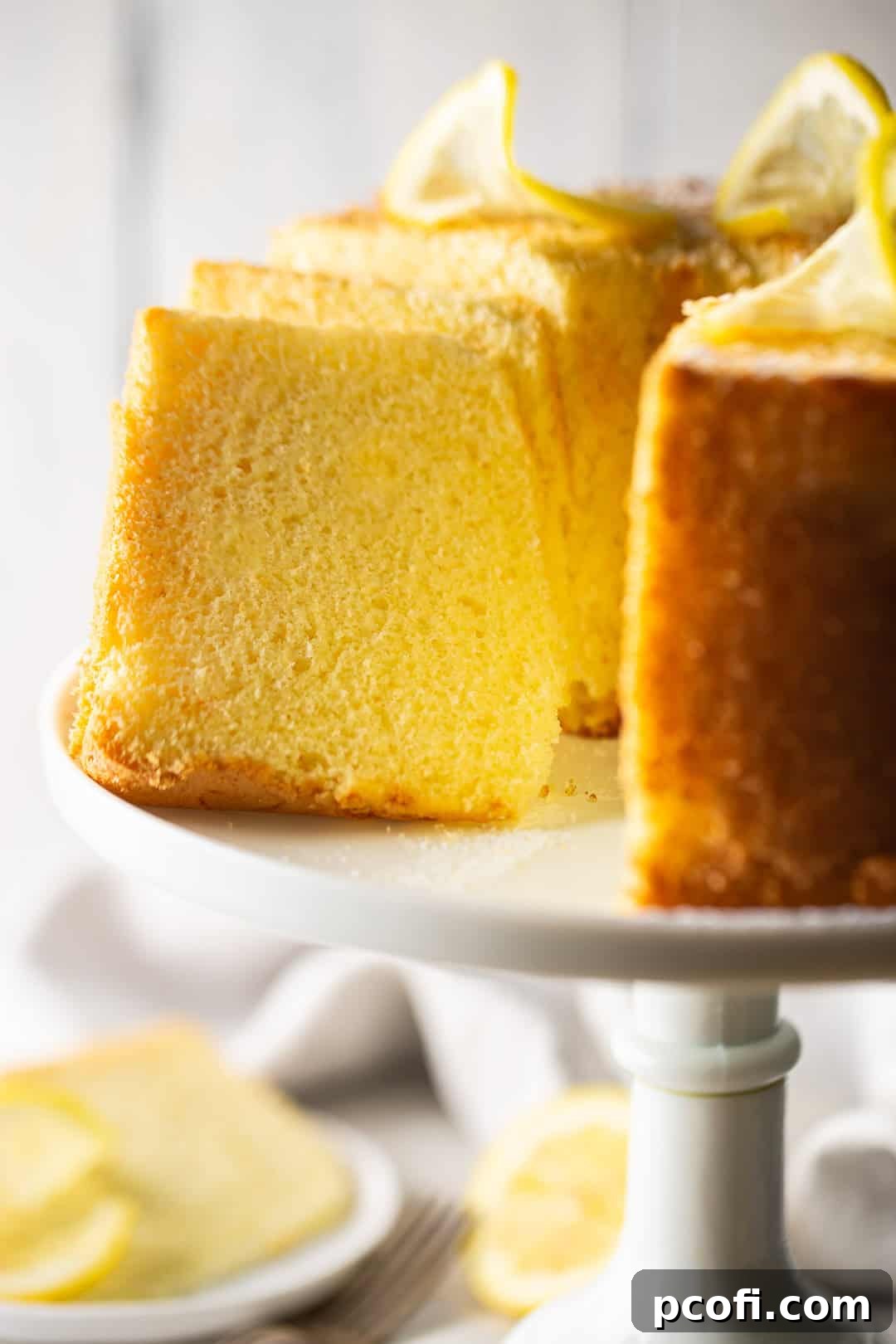 A close-up view of a slice of lemon chiffon cake, showcasing its uniquely spongy, open texture and delicate crumb.