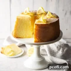 Lemon chiffon cake on a decorative white pedestal.