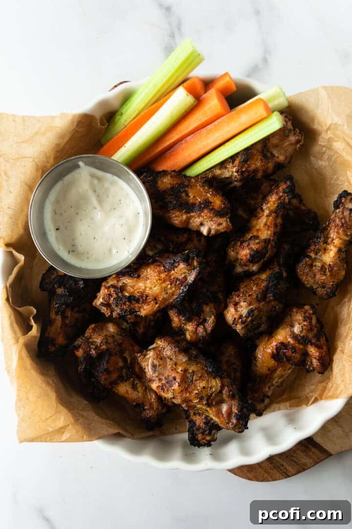 Grilled chicken wings arranged in a white dish, ready to be served with blue cheese dip.