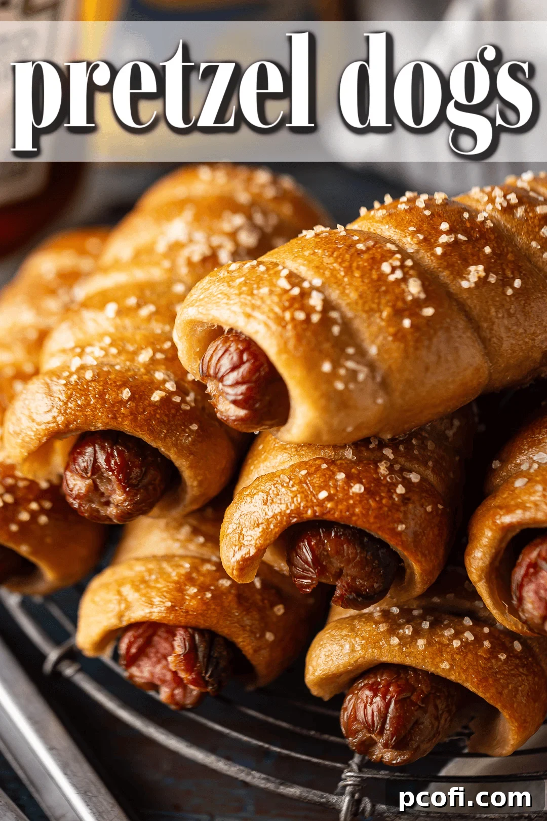 Prepared homemade pretzel dogs presented beautifully on a vintage rack, with kitchen tongs in the background, suggesting they are ready to be served.