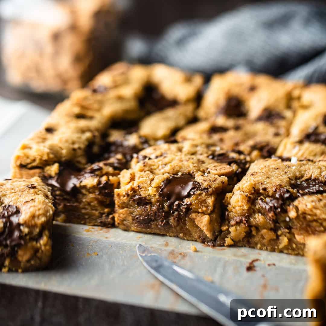 Peanut butter blondies, cut into squares on parchment paper, perfect for bake sales.