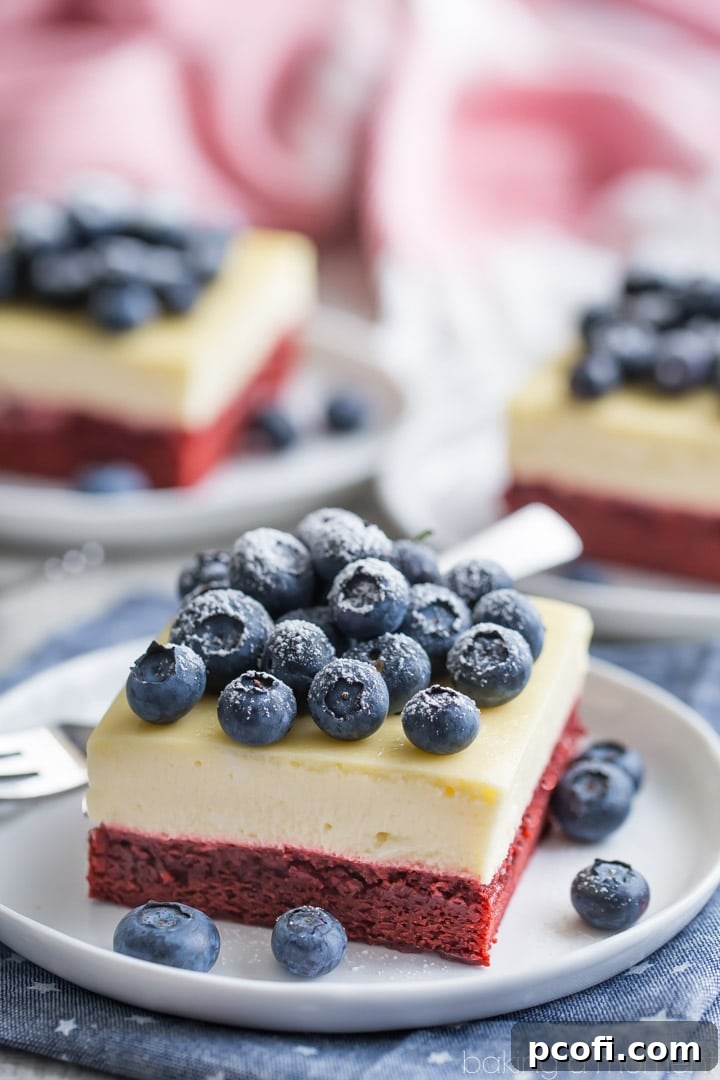 Festive red velvet cheesecake bars, featuring a rich cocoa buttermilk layer and creamy cheesecake, perfect for Fourth of July celebrations.
