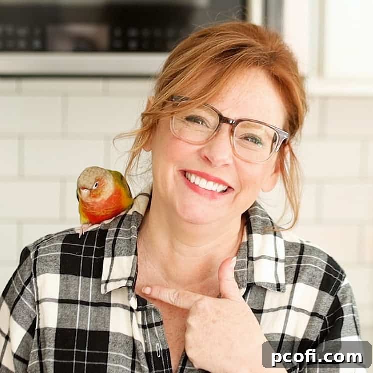Allie from Baking a Moment with Bertie, a delightful Pineapple Green-Cheeked Conure Parrot, symbolizing a new chapter in life.