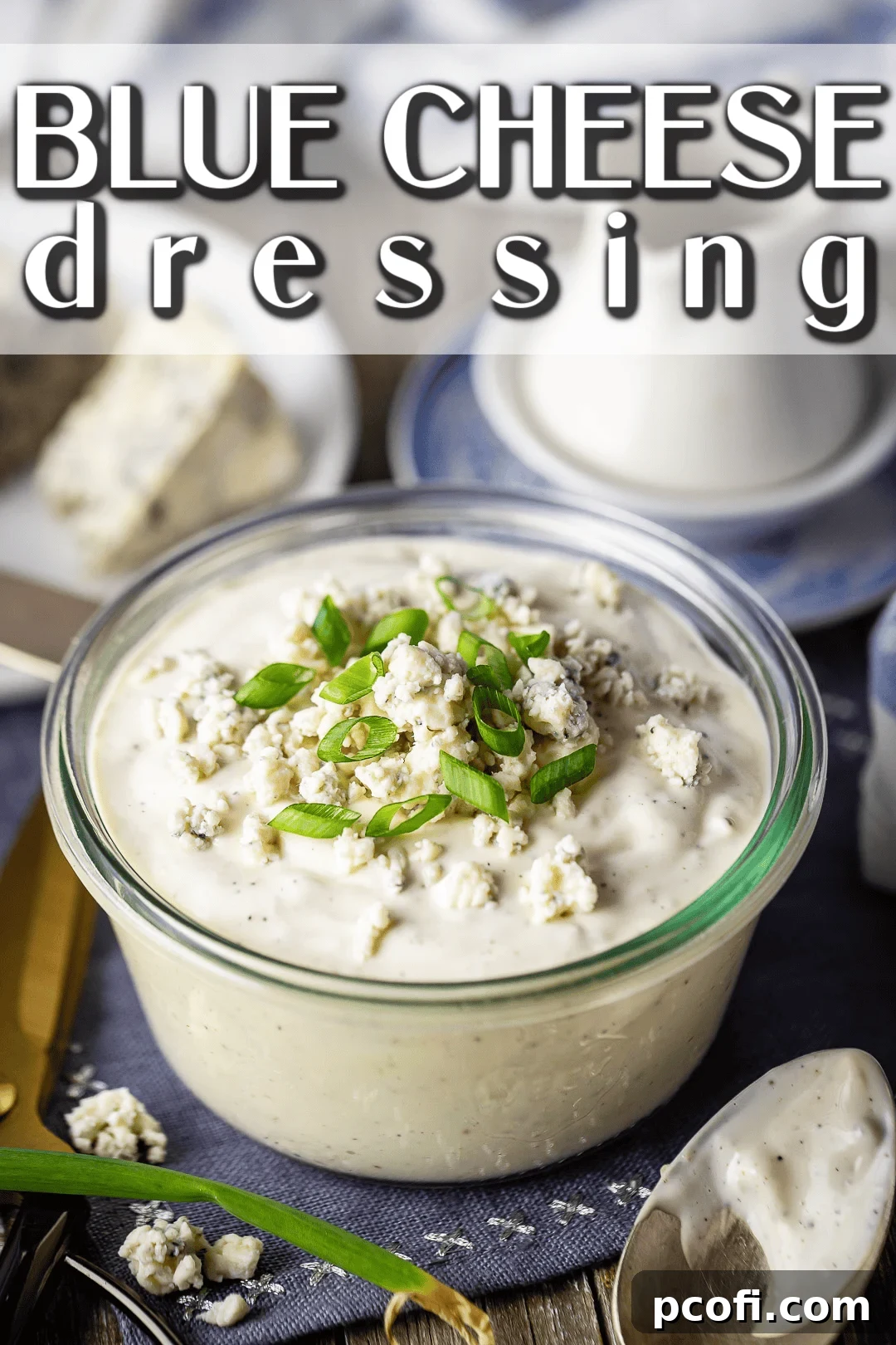 Homemade blue cheese dressing in a glass jar with a wedge of blue cheese in the background.