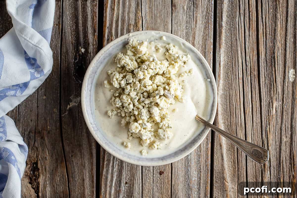 Adding blue cheese crumbles to the base.