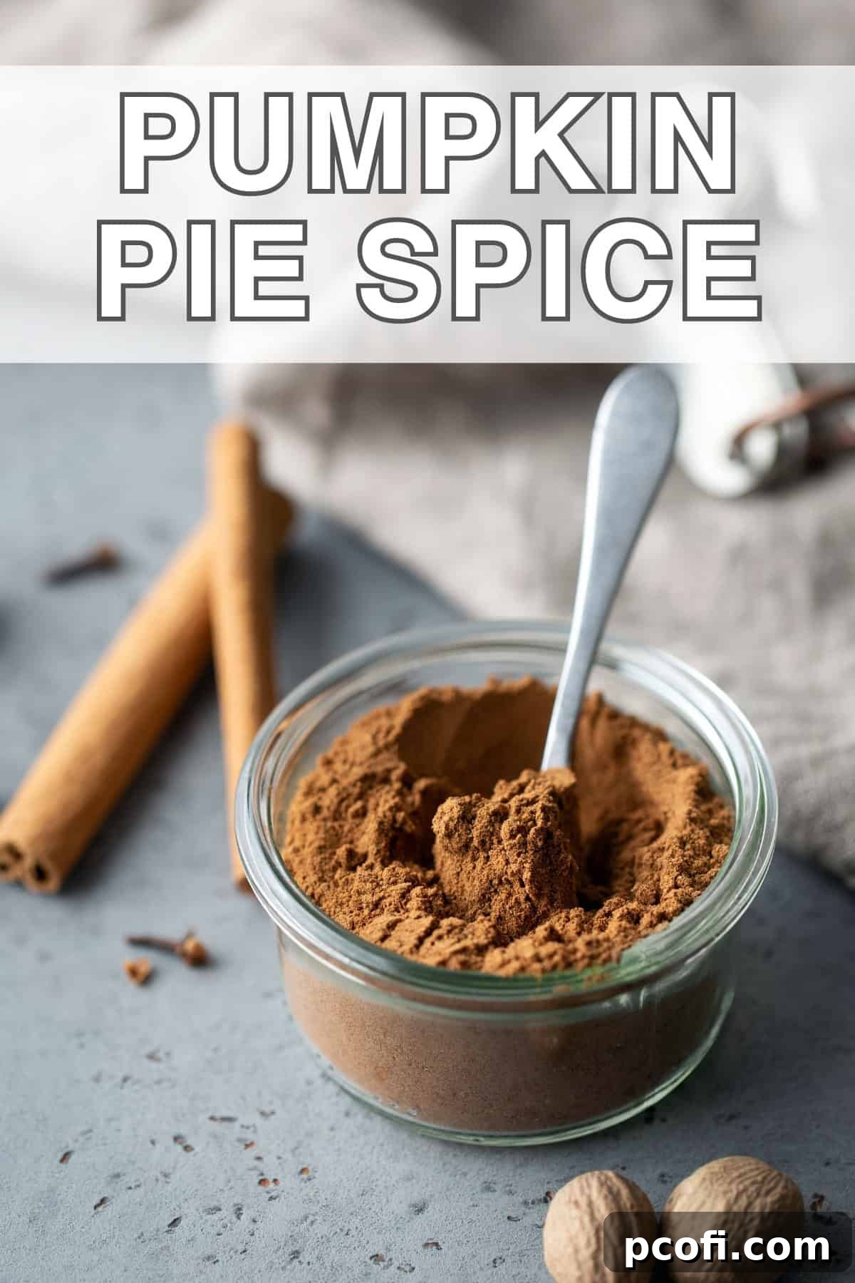 Pumpkin pie spice in a jar with a spoon, showing its rich color and texture