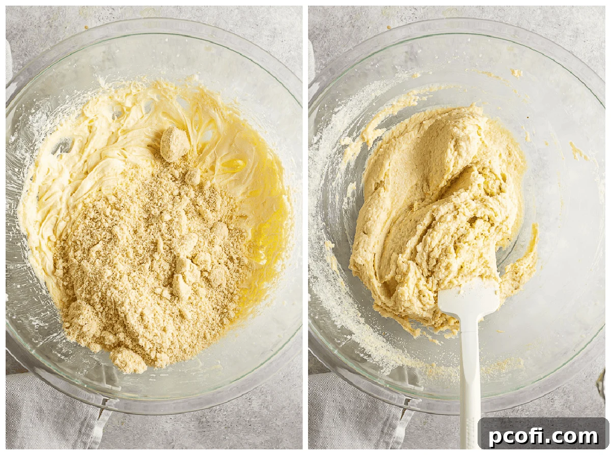 Folding almond meal into the creamy butter and egg mixture using a spatula.