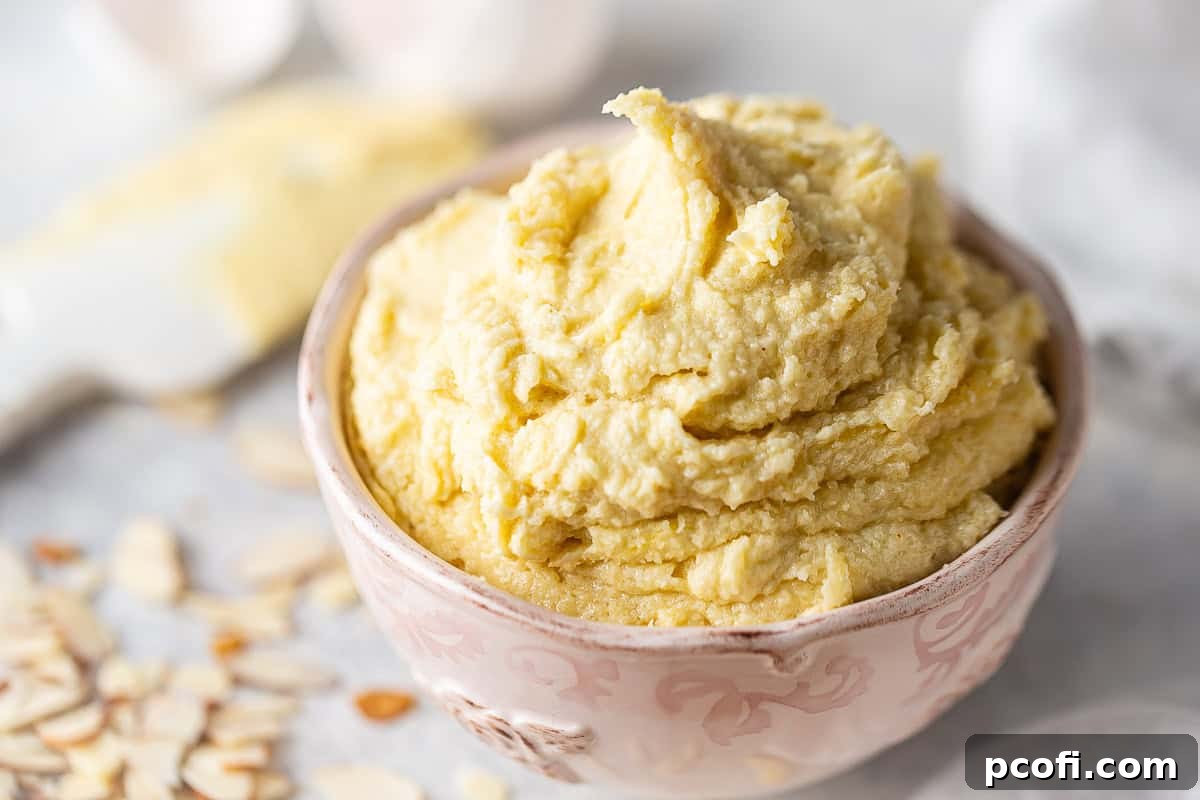 Close-up image of frangipane in a bowl, surrounded by toasted flaked almonds.