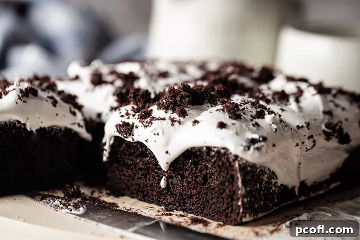 Devil's food sheet cake with Italian meringue and a blue cloth in the background.