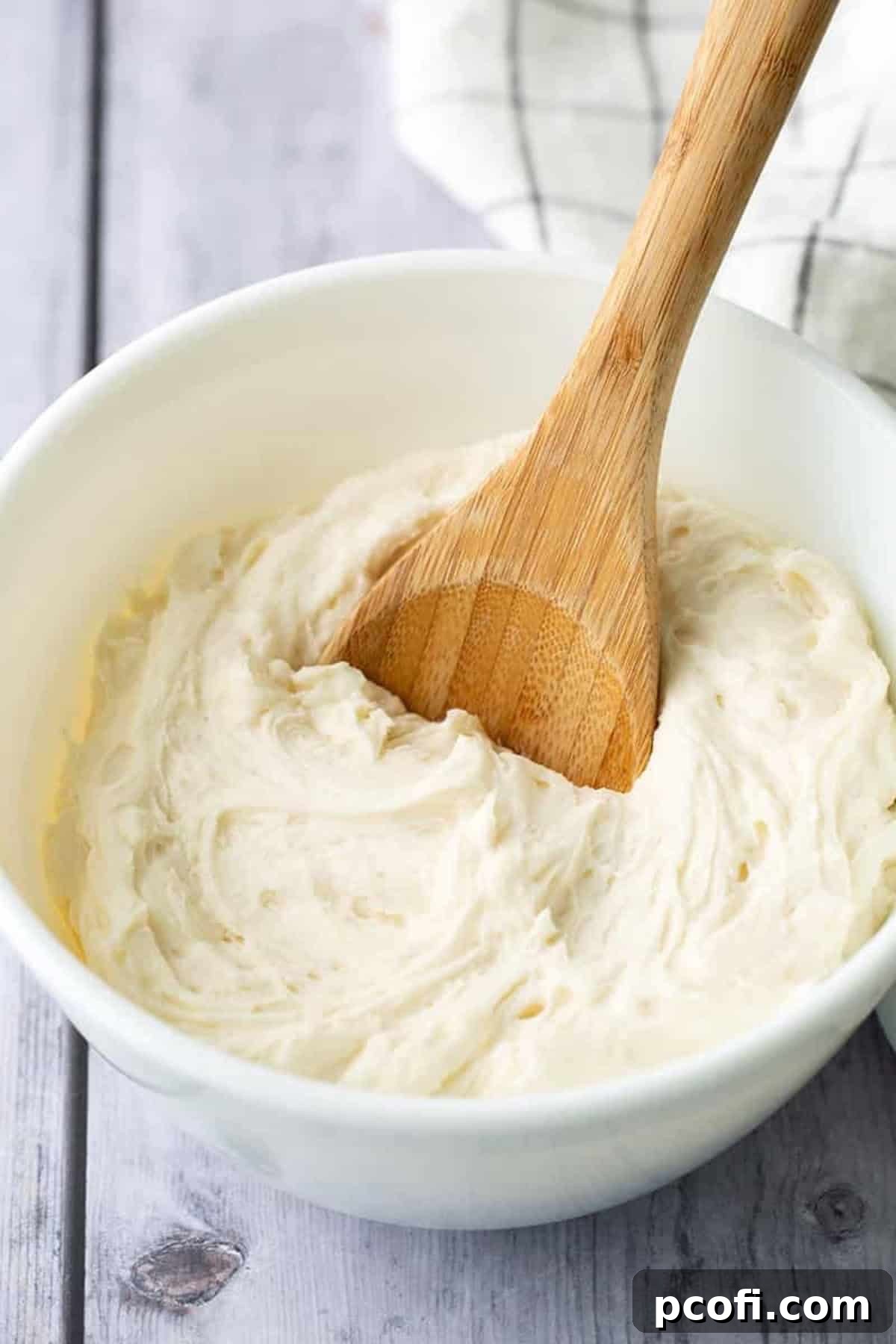 vanilla buttercream frosting in a bowl with a spoon.