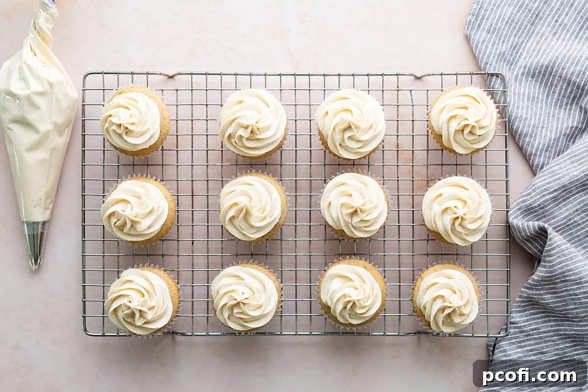 A beautifully frosted chai cupcake on a wire cooling rack, showcasing a perfect swirl of buttercream.