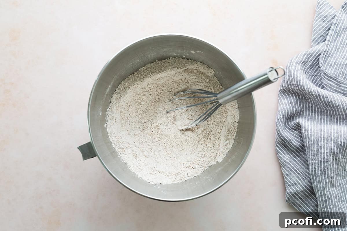 Dry ingredients for cupcakes, including flour, sugar, and spices, whisked together in the bowl of a stand mixer.