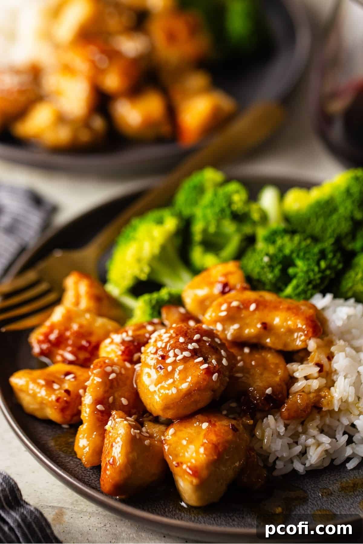 Crispy honey butter chicken topped with sesame seeds, served elegantly on a plate.