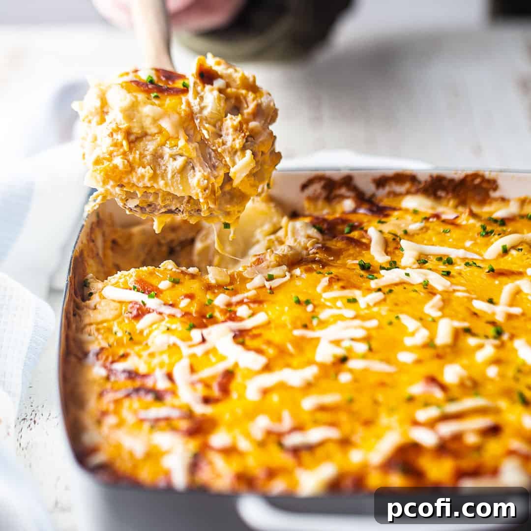 Serving creamy scalloped potatoes directly from the pan with a wooden spoon, showcasing their rich texture.